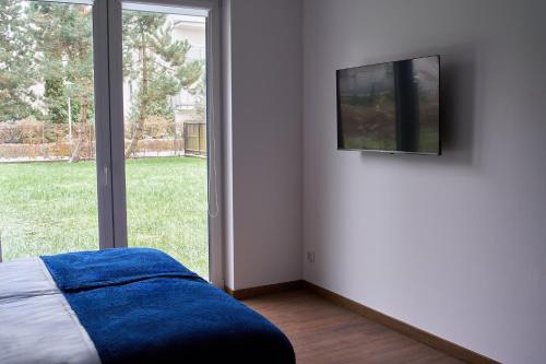 华沙Top Loft Znana的一间卧室配有一张床,墙上配有电视