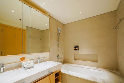 迪拜CitiHome-2BR creek harbour island的一间带大镜子和盥洗盆的浴室