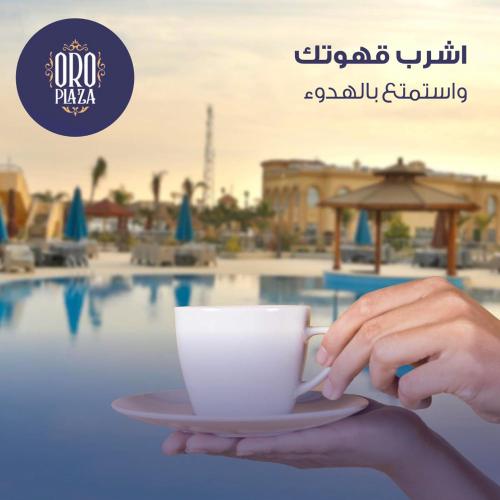 开罗فندق أورو بلازا ORO Plaza Hotel的持杯咖啡的人