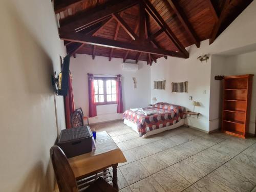 米娜克拉韦罗Cabanas Las Pencas, HOSTERIA的一间卧室配有一张床、一张桌子和一个窗户。