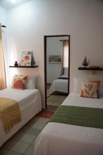 圣斐利-银港Hotel Montesilva的一间卧室配有两张床和镜子