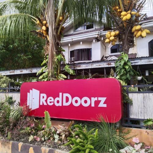 TumauiniMadria's Pension House Reddoorz的大楼前的红色门牌