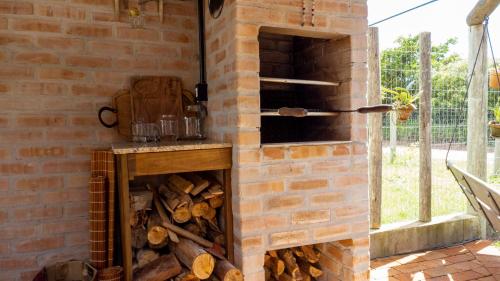 伊比拉奎拉Pousada Bosque das Águas, Imbituba的一堆烧木柴的砖炉