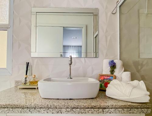 圣劳伦斯海滨Lindo Apto Riviera de São Lourenço Mod 3的浴室设有白色水槽和镜子