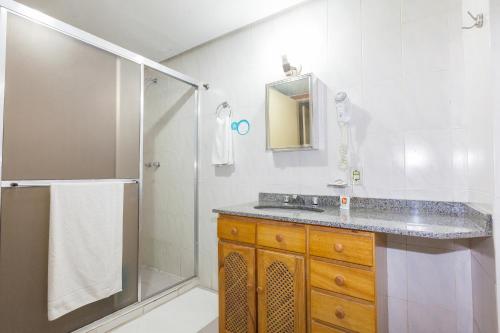 阿雷格里港Letto Hotel Porto Alegre的带淋浴、盥洗盆和镜子的浴室