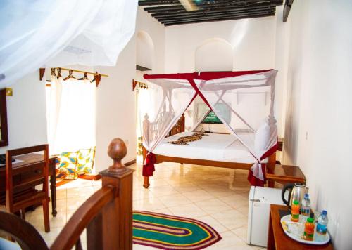 Stone TownLa Neisha Hotel Zanzibar的一间卧室配有一张带蚊帐的床
