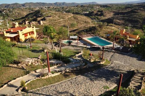 维拉卡洛斯帕兹Cabañas Terrazas del Sol的享有房子和游泳池的空中景致