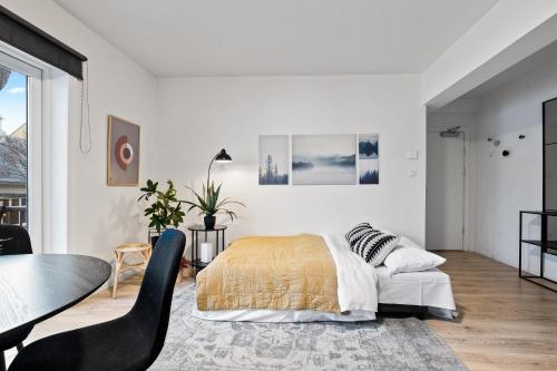 雷克雅未克Venture Vacation - Cozy and Central Apartment的卧室配有1张床、1张桌子和1把椅子