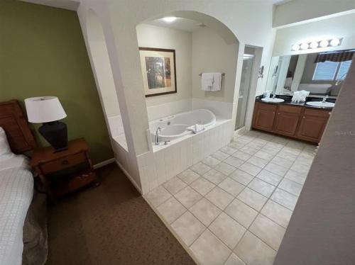 奥兰多Best Disney Resort Condo Orlando的带浴缸的大浴室和卧室