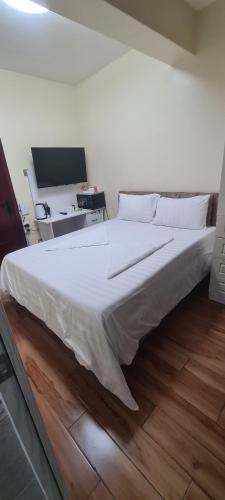 内罗毕JVcribstudios-Ndemi gardens apartments的一张大白色的床,位于带书桌的房间里