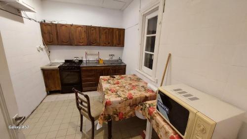 马德普拉塔Hostería Almirante Brown的一间带桌子和微波炉的小厨房