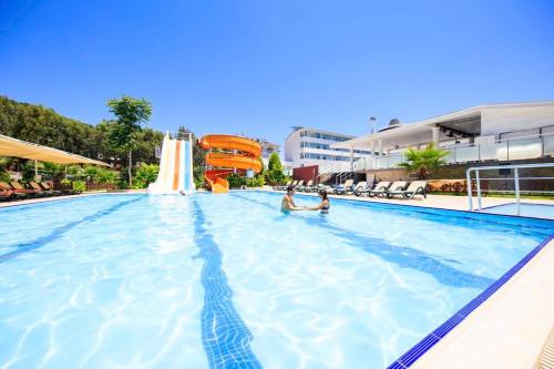 凯麦尔Jura Hotels Kemer Resort的两人在度假村的游泳池里