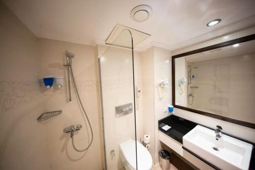 凯麦尔Jura Hotels Kemer Resort的带淋浴、卫生间和盥洗盆的浴室