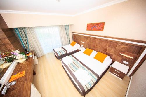 凯麦尔Jura Hotels Kemer Resort的大房间设有两张床和一张书桌