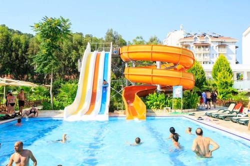凯麦尔Jura Hotels Kemer Resort的一群人在带水滑梯的游泳池里