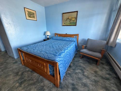 拉顿Maverick Motel的一间卧室配有一张床和一把椅子