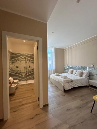 卡拉拉Breccia Nel Mare的卧室配有一张床,墙上挂有绘画作品