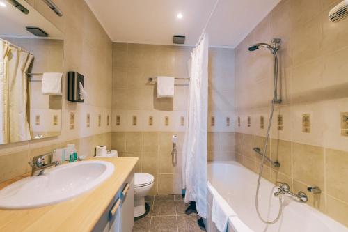 尼诺纲德卡瓦尔酒店的一间带水槽、浴缸和卫生间的浴室