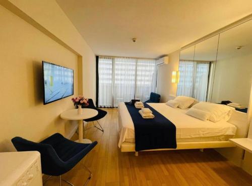 巴统Orbi City apartment with sea view的一间卧室配有一张大床和一张桌椅