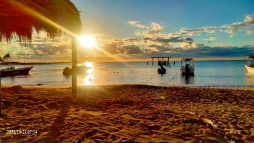 普拉亚卡门LYJ HOTEL Hab 21的海滩上的日落,在水中乘船