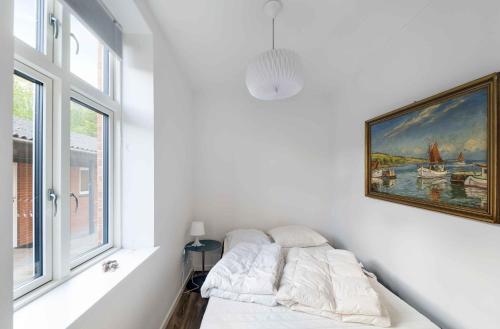 斯瓦讷克Holiday Apartment At Beautiful Solgaarden 8的白色的房间,配有沙发和墙上的绘画