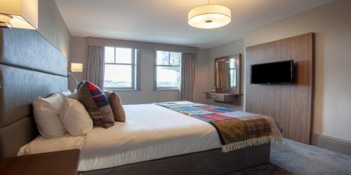 哈罗盖特The Yorkshire Hotel的配有一张床和一台平面电视的酒店客房