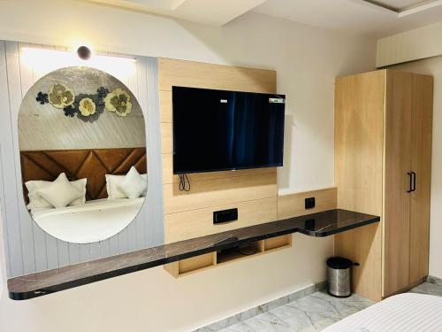 艾哈迈达巴德Hotel Marigold Naroda的一间设有镜子的墙上电视的房间