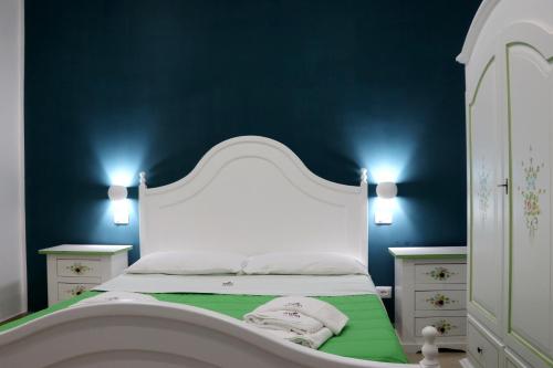 帕埃斯图姆B&B Villa Anna的卧室配有白色床和蓝色墙壁