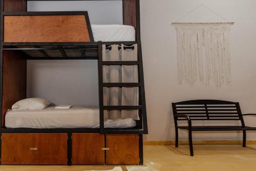 坎昆Caleta Hostel Rooftop & Pool的一间卧室配有一张双层床、椅子和吊灯