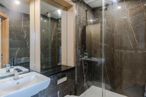 伦敦The King's Residence - St Pancras - by Frankie Says的一间带水槽和玻璃淋浴的浴室