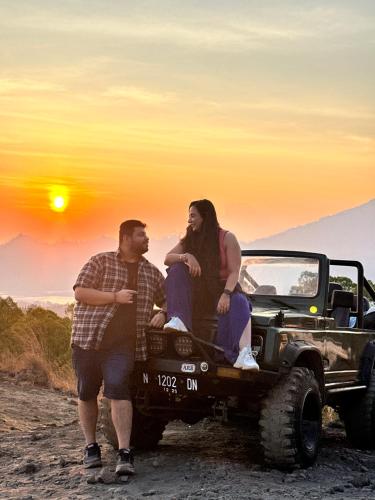 库布盼洛坎Batur volcano sunrise jeep的坐在卡车后面的男人和女人