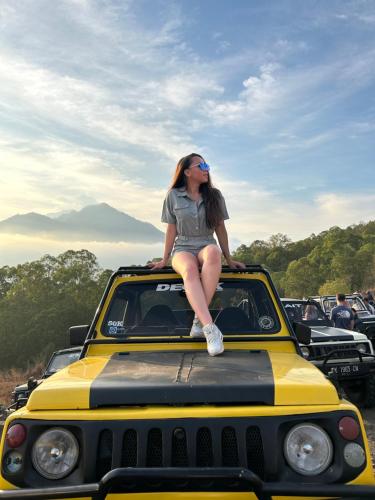 库布盼洛坎Batur volcano sunrise jeep的坐在汽车顶上的女人