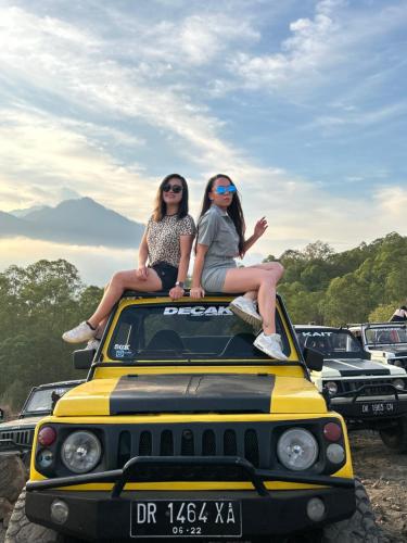 库布盼洛坎Batur volcano sunrise jeep的两个女人坐在吉普车顶上