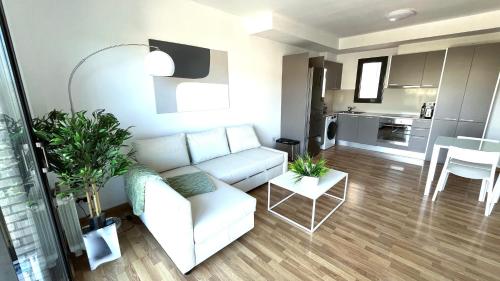 特拉萨Dúplex con terraza by Prestigi的一间带白色沙发的客厅和一间厨房