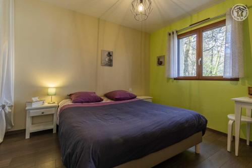 BassensA l'oree des monts的一间卧室配有一张带紫色床单的床和窗户。