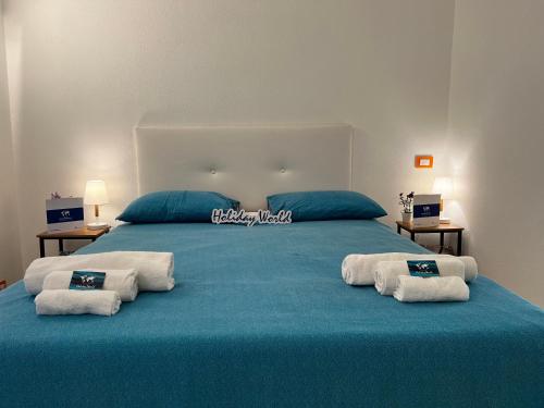 皮耶韦利古雷House Vanja by Holiday World的一张大床,上面有蓝色的床单和白色的毛巾