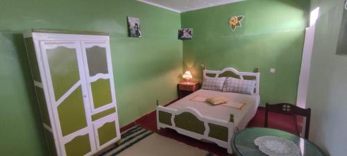 Ti nʼAmaraNatural Farming的一间绿色的小卧室,配有床和门