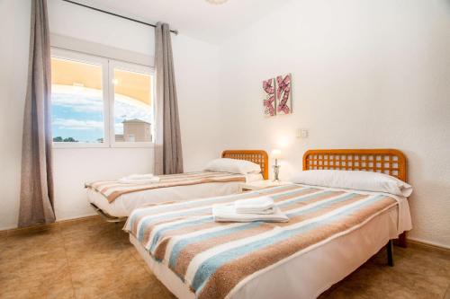 卡尔佩Villa Zelda - PlusHolidays的带窗户的客房内的两张床