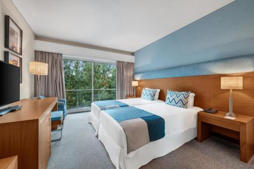 英雄港杜卡拉科尔酒店的酒店客房设有一张大床和一张书桌。
