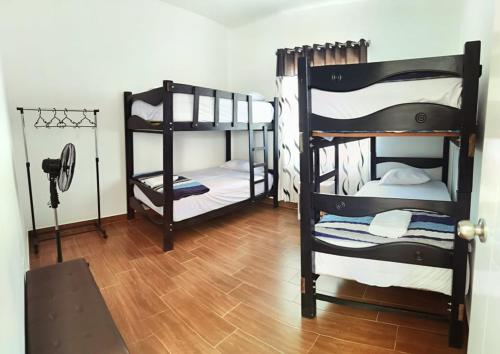 帕拉卡斯Bungalow Sol del Sur的客房设有两张双层床,铺有木地板。