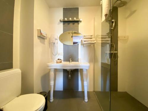 Auvelais阿弗勒尔日库埃特酒店的一间带水槽、镜子和卫生间的浴室