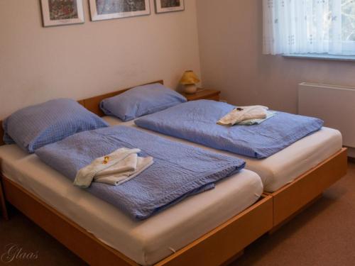 Reichshof Hotel-Restaurant Denklinger-Hof的客房内的两张床,上面有蓝色的毛巾