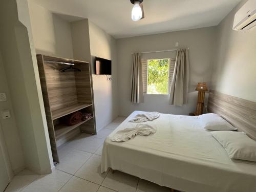 博尼图Solar do Cerrado Hotel的卧室配有白色的床和窗户。