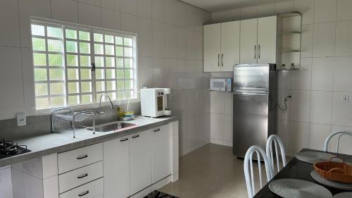 巴西利亚Linda casa em condomínio fechado的厨房配有白色橱柜和不锈钢冰箱