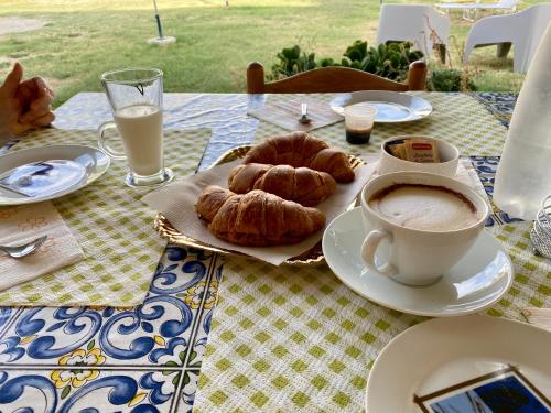 VillareiaB&B Villa Angela Via della bonifica 17的桌上放着咖啡和羊角面包
