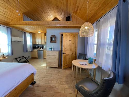 布拉夫柳树街度假屋的一间卧室配有一张床铺和一张桌子,还设有一间厨房