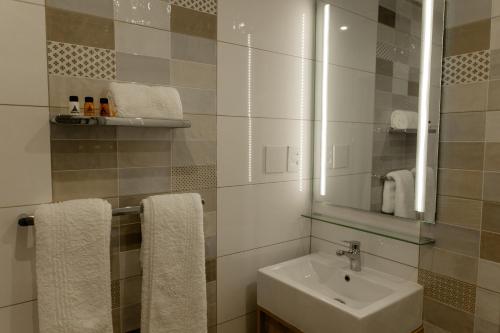 克莱克斯多普Acres Inn Klerksdorp的浴室配有盥洗盆、镜子和毛巾
