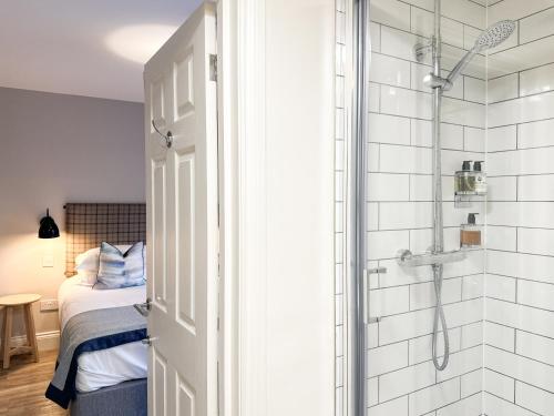 锡豪西斯Beach House Hotel的带淋浴、床和淋浴的浴室