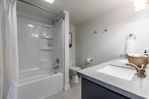 罗切斯特Modern 2 Bed/1 Bath, In-Unit Laundry, Parking + 6 Blocks from Mayo的白色的浴室设有水槽和淋浴。