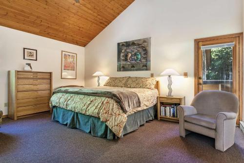 比弗河Stone Creek Dr 243的卧室配有床、椅子和窗户。